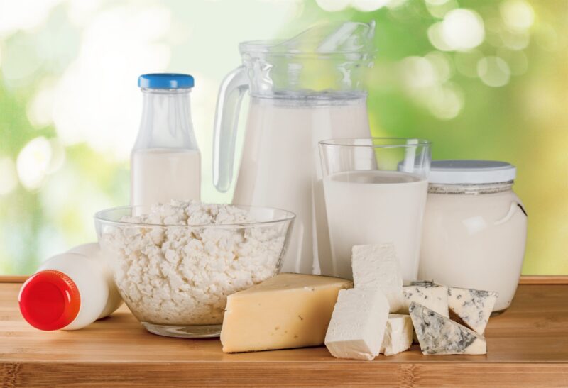 Glass of milk and dairy products on background